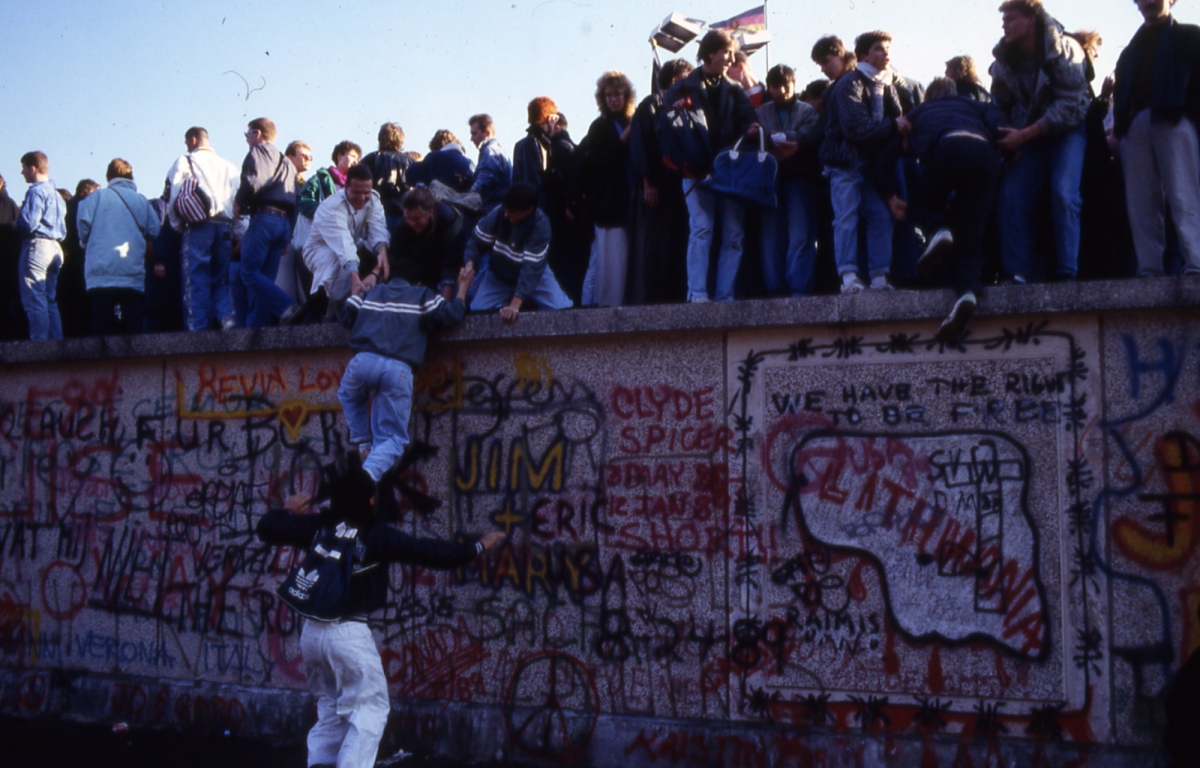 Menschen auf der Berliner Mauer während des Mauerfalls